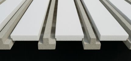 Conjunto de placas brancas de EPS posicionadas sobre vigotas de concreto em estrutura de laje pré-moldada.